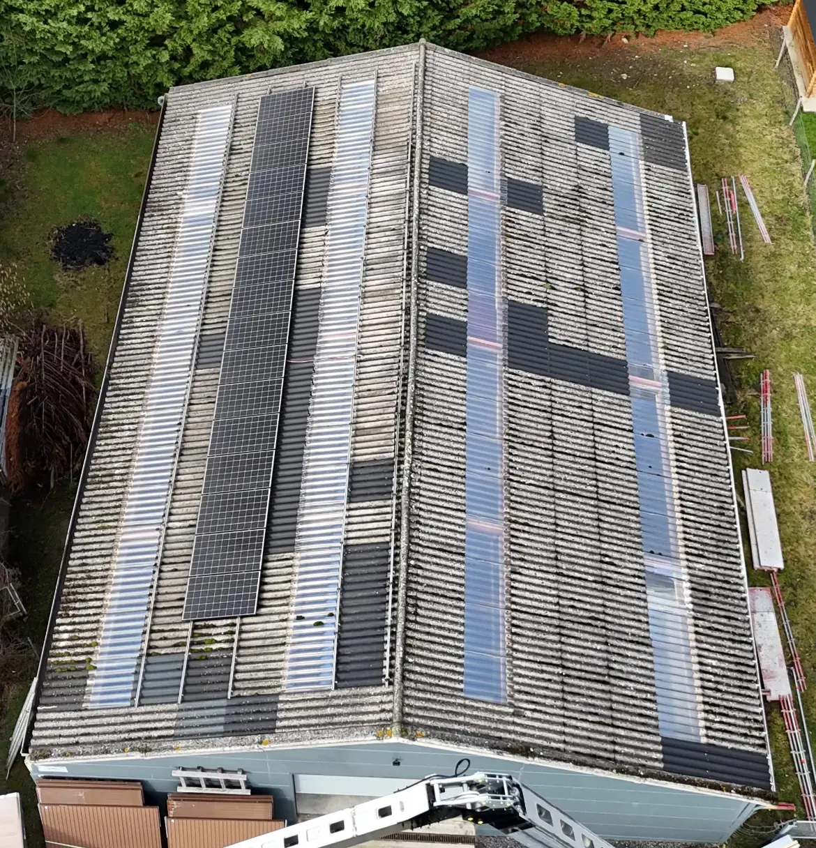 Toiture de bâtiment en fibrociment avec plaques translucides, en cours de rénovation