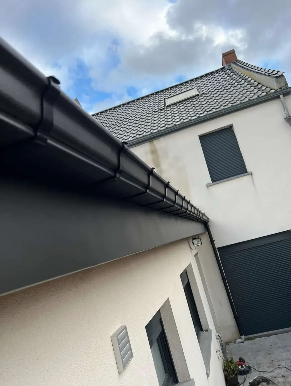 Gouttière neuve en angle sur une maison blanche