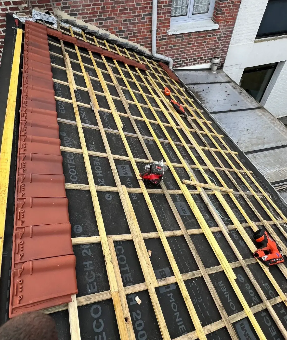 Liteaux neufs posés sur l’écran de sous-toiture avant la pose des tuiles