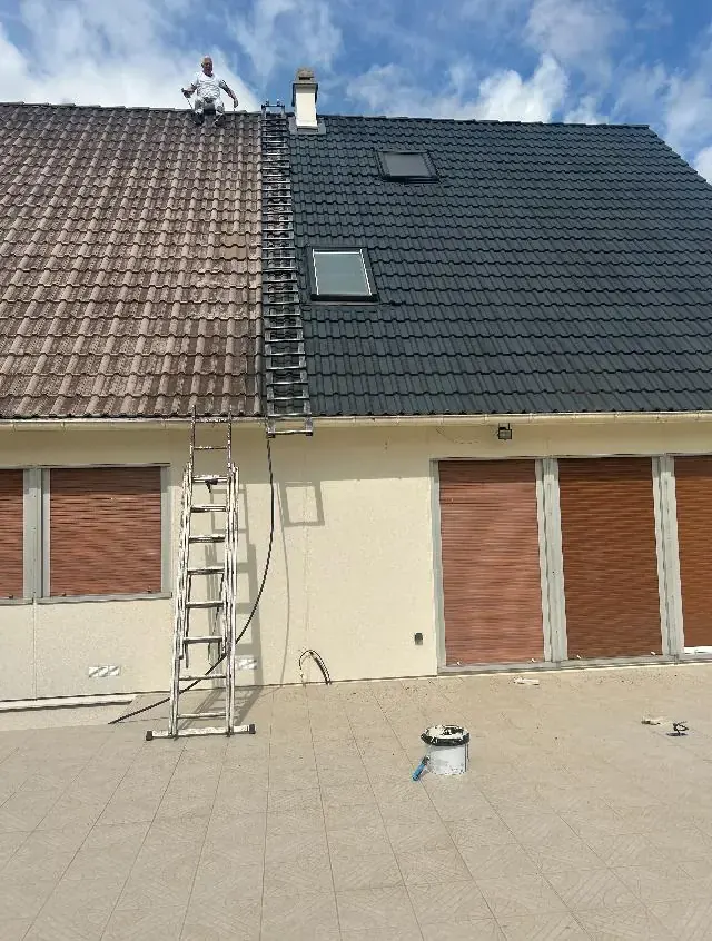 Couvreur sur une toiture en tuiles, une moitié du toit déjà traitée