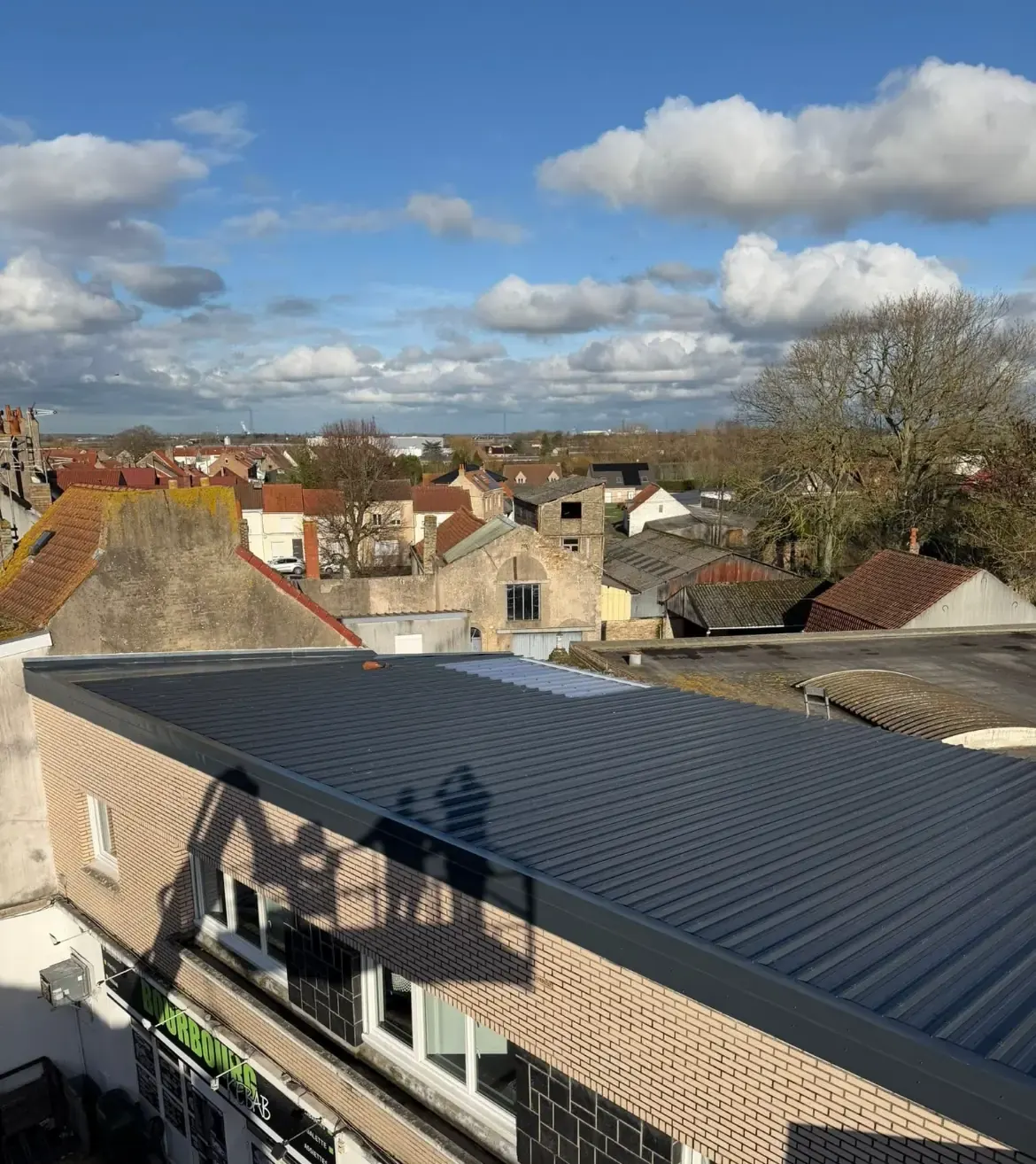 Toiture en bac acier gris anthracite refaite, vue d’en haut sur les toits du quartier